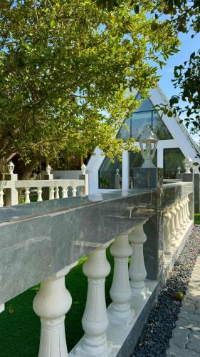 a row of white vases in front of a building at Villa farm with Huge facilities 2 pools in Kalbā