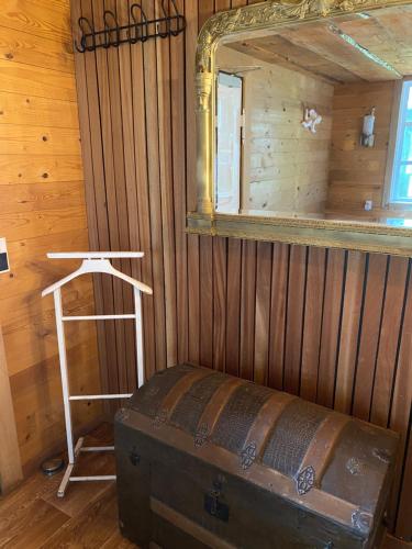 a mirror and a stool in a room with a trunk at Klondike City in Vojens