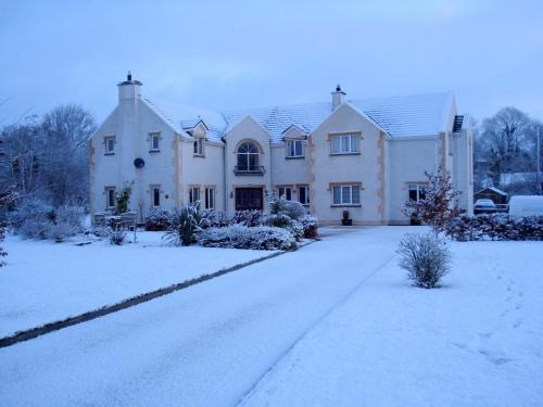 a large white house with snow on the driveway at Dungimmon House in Ballyconnell