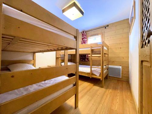 Ce lit se trouve dans un dortoir doté de 2 lits superposés et de murs en bois. dans l'établissement Chalet Adele - Pied de piste, appartement spacieux et confortable pour 6 MAE-4564, à Saint-Martin-de-Belleville