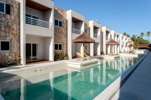 ein Schwimmbad vor einem Gebäude in der Unterkunft Apartamentos Moana Milagres - Rota Ecológica Milagres in Barra do Camaragibe
