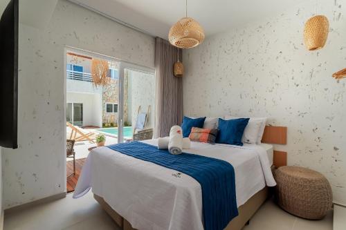 ein Schlafzimmer mit einem Bett, auf dem ein Teddybär liegt in der Unterkunft Apartamentos Moana Milagres - Rota Ecológica Milagres in Barra do Camaragibe