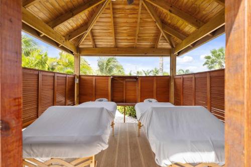 a row of beds in a room with wooden walls at Eagle Beach - Luxury Beachscape 2BR condo - LV302 in Palm-Eagle Beach