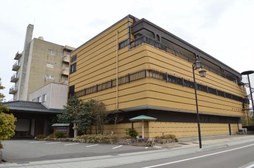a yellow building on the side of a street at Kanoya Kourakuen in Kaga