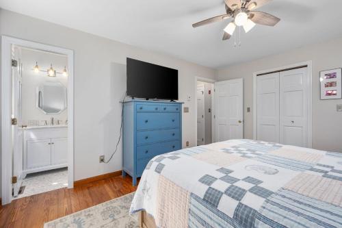 a bedroom with a blue dresser and a tv at 4 Harvest Hollow Harwich Port Cape Cod- - We Shall Sea in Harwich Port