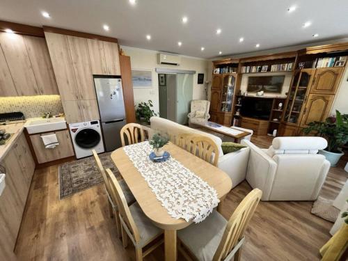 a living room with a dining table and a kitchen at Petofi Downtown in Kecskemét