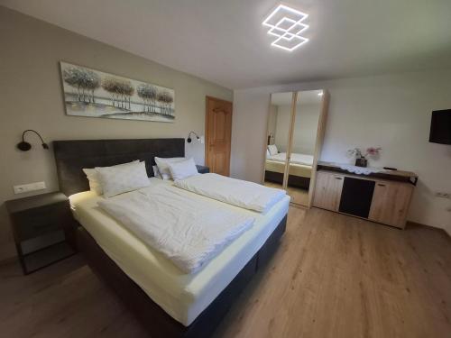 a bedroom with a large bed and a mirror at Ferienwohnung Haas Maria in Neustift im Stubaital