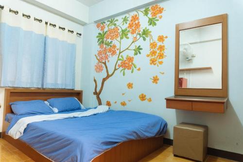 1 dormitorio con 1 cama con un mural en la pared en Chiangmai Tree Hostel, en Chiang Mai