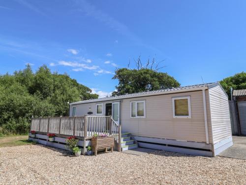 a tiny house with a porch and a bench at The Hideaway in Weymouth