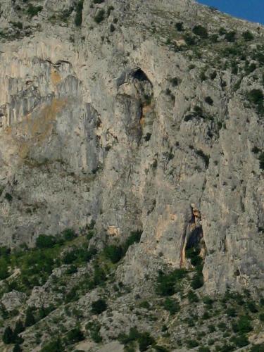 a rocky mountain with an opening in the side of it at Adria Apartments in Podgora