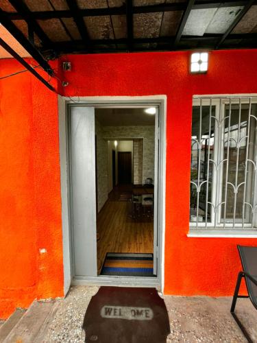 a red wall with an open door to a room at Central House in Kutaisi
