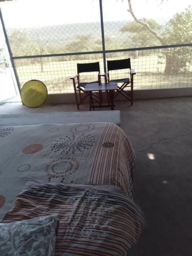 a bed and a table and chairs on a balcony at Mara Moon cottages in Sekenani