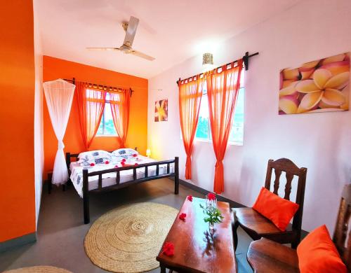 a room with two beds and a table in it at Frangipani House Nungwi Zanzibar in Nungwi