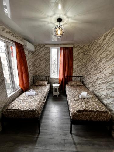 a room with two beds and two windows at Central House in Kutaisi