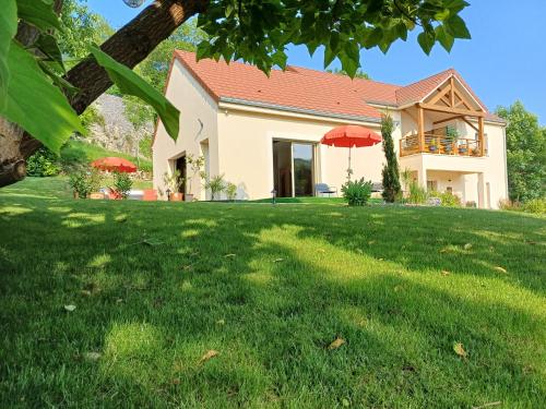 a house with red umbrellas in a yard at Bélénos - Suites & Spa in Bligny-sur-Ouche