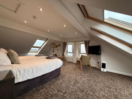 a bedroom with a large bed in a room with windows at Antrim House Guest Rooms & Suites in Portrush