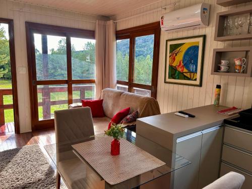 a kitchen and living room with a table and a couch at Cabana das Montanhas in Caxias do Sul