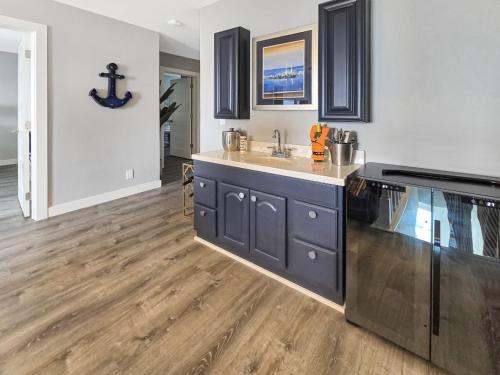 a kitchen with black cabinets and a wooden floor at AWave From It All lakefront on Big Spirit Lake in Orleans