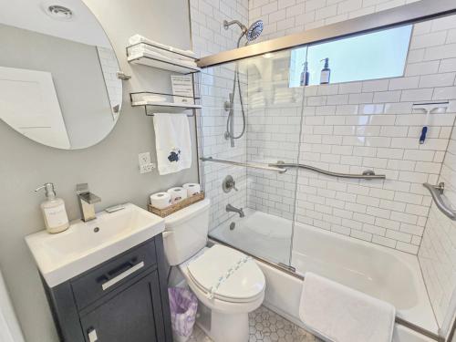 a bathroom with a sink and a toilet and a shower at AWave From It All lakefront on Big Spirit Lake in Orleans