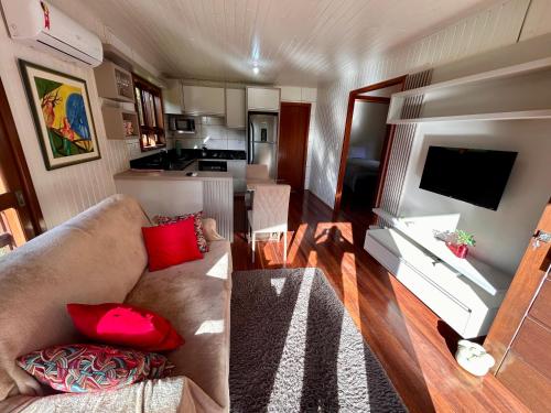 a living room with a couch and a kitchen at Cabana das Montanhas in Caxias do Sul
