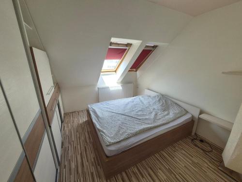 a small room with a bed and a window at Quelle Apartment in Kecskemét