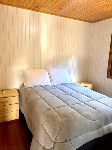 a bedroom with a large bed with a wooden ceiling at Cabana das Montanhas in Caxias do Sul