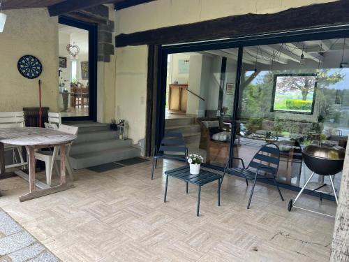 - un salon avec une table, des chaises et une table dans l'établissement Maison de campagne, à Erbrée