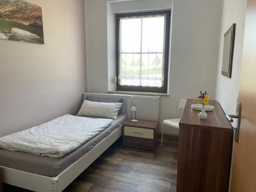 a small bedroom with a bed and a window at Gästewohnung 1 Zum Stadtwald Spremberg in Spremberg