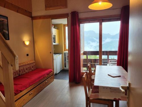 une chambre avec une table et une salle à manger avec une fenêtre dans l'établissement Résidence Le De 1 - Deux pièces à proximité des pistes MAE-9541, à Aime La Plagne