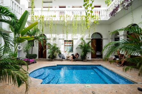 a swimming pool in a courtyard with plants at Masaya Santa Marta in Santa Marta
