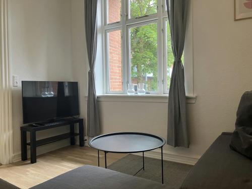 a living room with a table and a window at Central and Spacious Apartment for 4 in Esbjerg