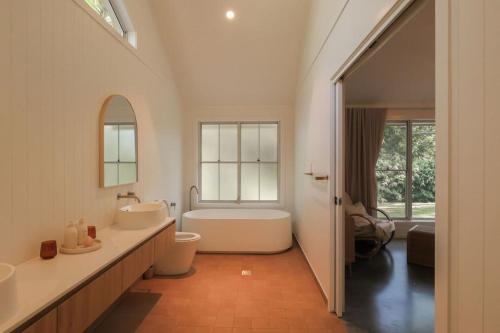 a bathroom with a white tub and a sink at Bailan Byron Serene Luxury Villa in Ewingsdale