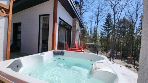 d'une baignoire sur le côté de la maison. dans l'établissement Le Renard Blanc - Spa and Incredible View, à Saint-Alexis-des-Monts