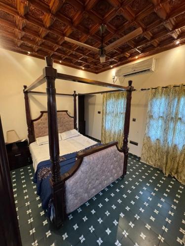 a bedroom with a canopy bed in a room at Thampurans lakefront properties in Changanācheri