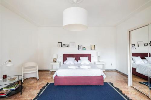a white bedroom with a large bed and a mirror at Casa del Vigneto in Spinea