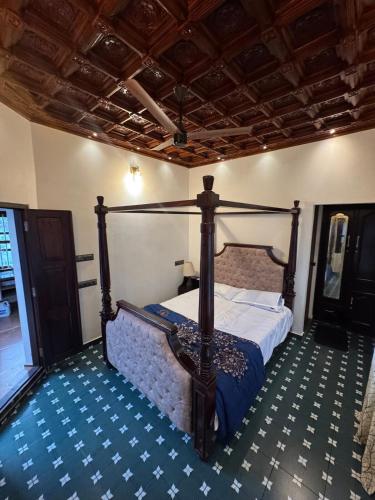 a bedroom with a canopy bed in a room at Thampurans lakefront properties in Changanācheri