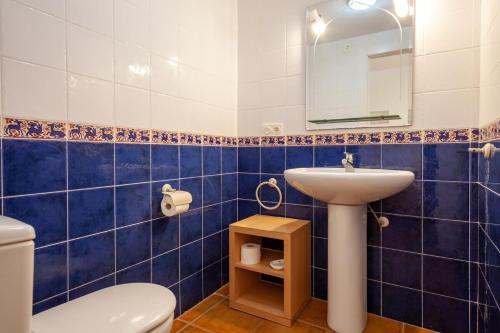 a blue tiled bathroom with a toilet and a sink at Heavenly Homes Mojcar 93 in Mojácar