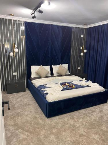 a bedroom with a large bed with a blue headboard at Casa Bella in Frăteşti