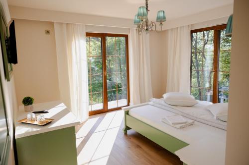 a bedroom with a bed and a large window at PENSIUNE RESTAURANT POIANA AVRIGULUI loc de joaca pentru copii in Avrig
