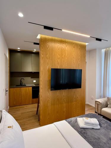 a hotel room with a television on a wooden wall at SUV ApartHotel in Pogradec