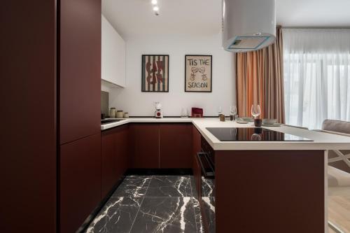 Ace of Hearts 1 BR APARTMENT,Parking, Fast wi-fi in One Cotroceni في بوخارست: مطبخ بدولاب بني وقمة بيضاء