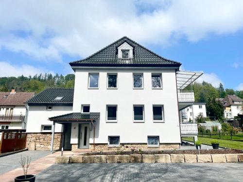 a white house with a black roof at Schlaffässer Ferienhaus Berger in Bad Karlshafen