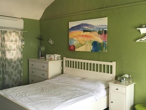 a bedroom with a bed and a painting on the wall at 自然海naturalhigh in Dahan