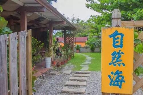 a sign on a fence next to a garden at 自然海naturalhigh in Dahan