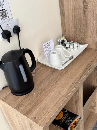 a black tea kettle on a wooden table at The Waverley Inn in Dingwall