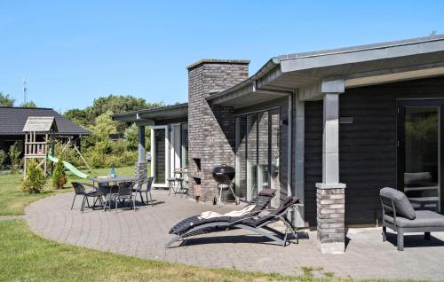 a patio with chairs and a table and a grill at Awesome Home In Glesborg With Sauna in Glesborg