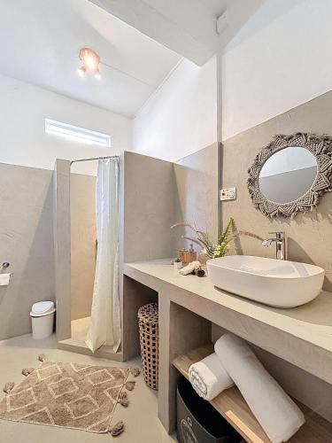 a bathroom with a sink and a mirror at Villamarday - Coquette villa privée au bord de l'océan in Pointe aux Cannoniers