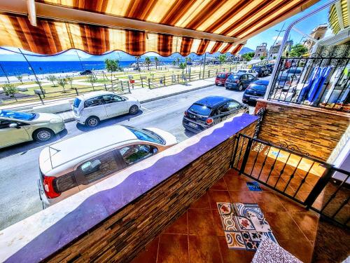a balcony with a view of a parking lot with cars at Seafront House Gabbiano Blu in Santa Flavia