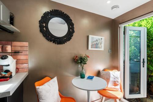 a dining room with a table and chairs and a mirror at Tiny House with Parking & Patio by Cool Bloo in Brighton & Hove