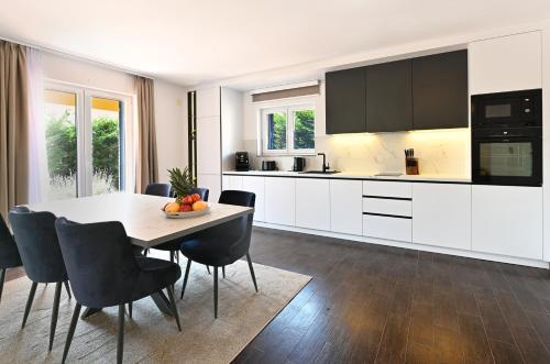 a kitchen with a table and chairs and a kitchen with white cabinets at Villa Katarina in Vilanija